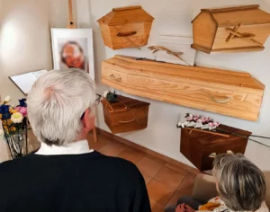 Exposition de différents modèles de cercueils en bois dans un salon funéraire.